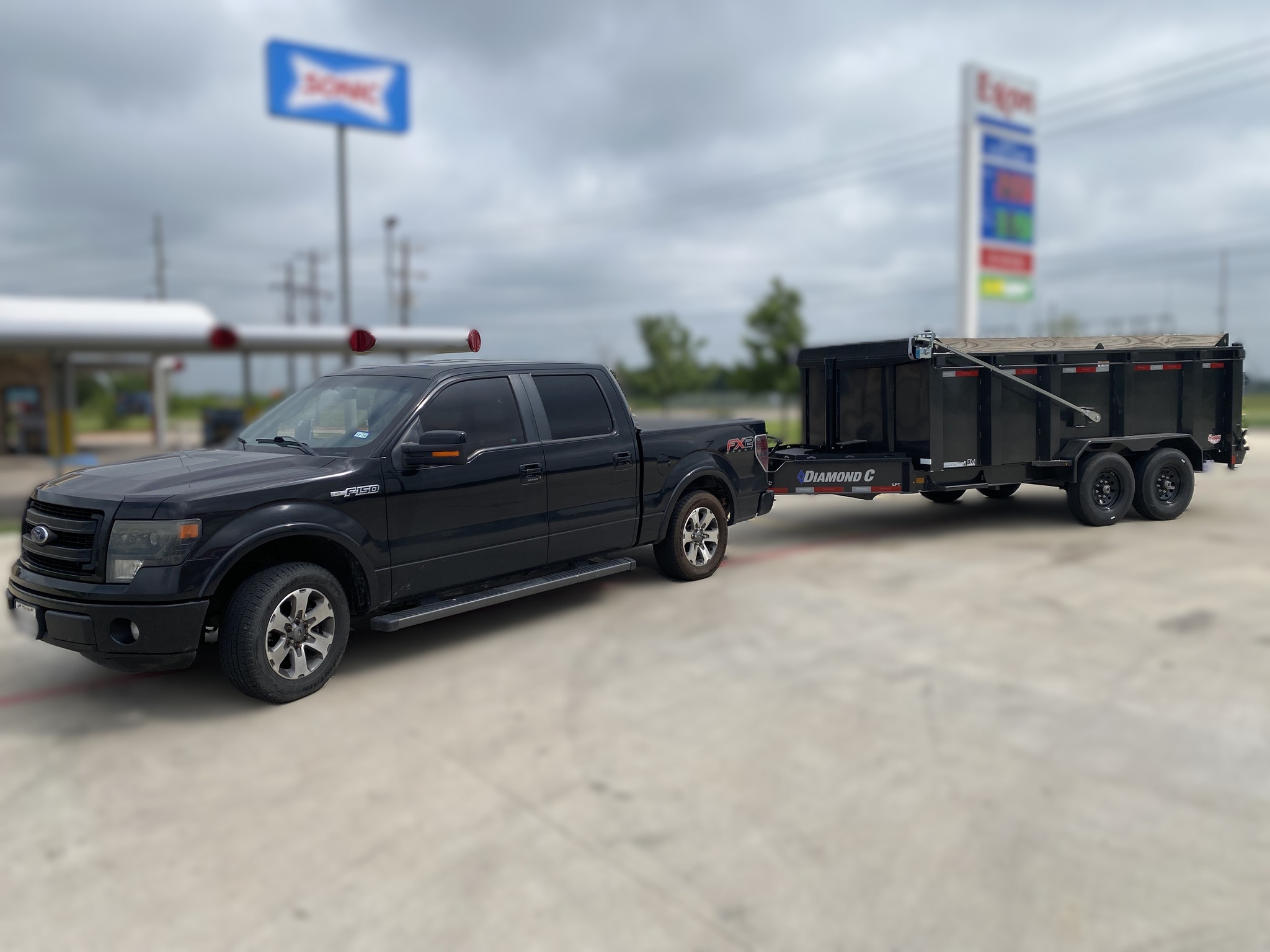 Dump trailer hitched to F-150 pickup truck showing tow vehicle scale in Keller TX