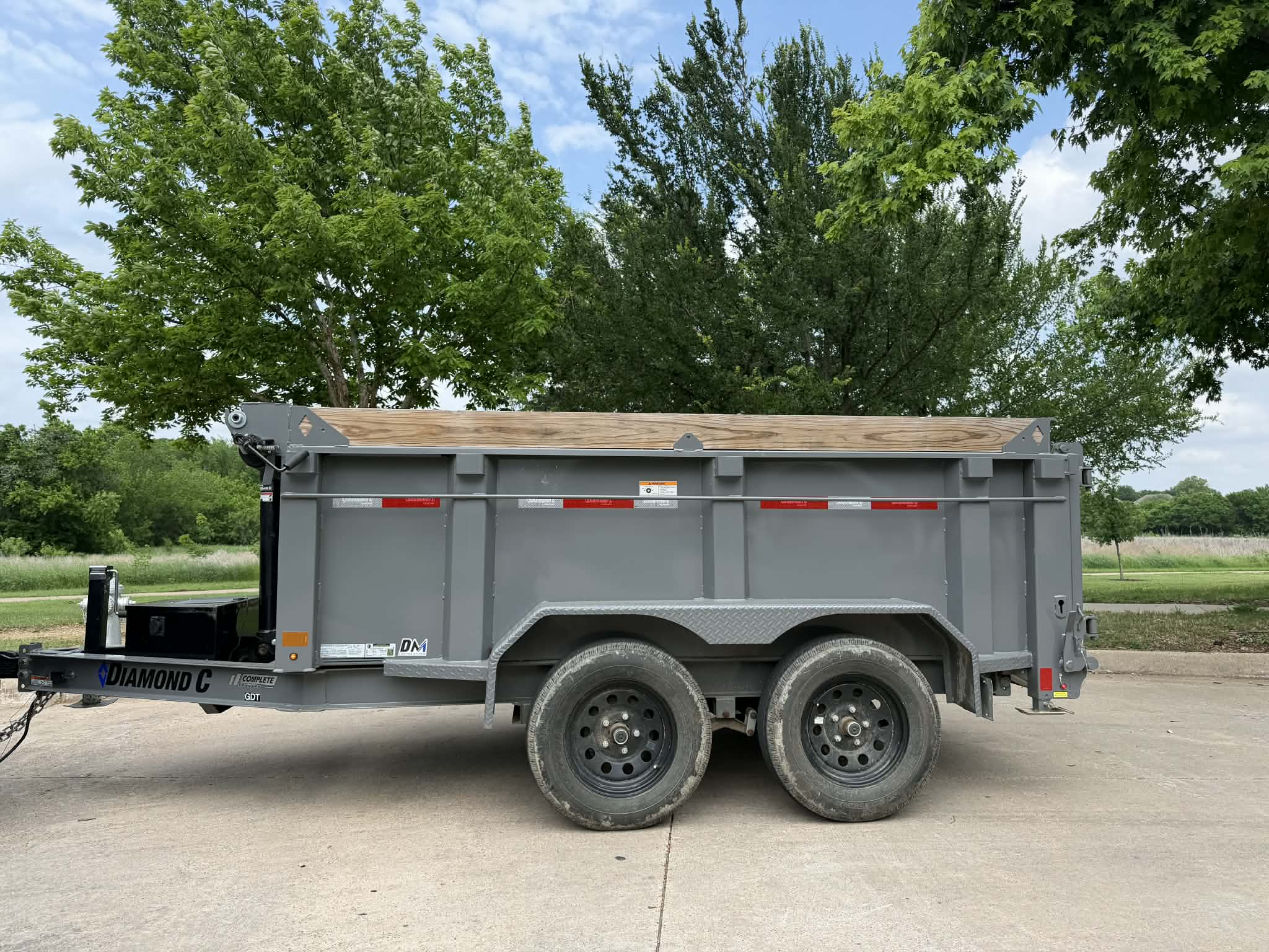 Dual-axle dump trailer with wood board extensions in Fort Worth TX